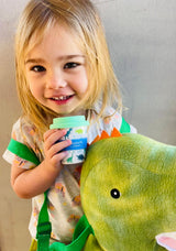 girl holding dinosaur babycino cup