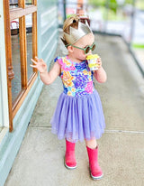 girl dressed in tutu with gumboots and crown golding a yellow pineapple babychino cup