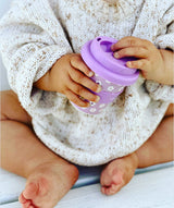 baby holding purple daisy flower babycino cup