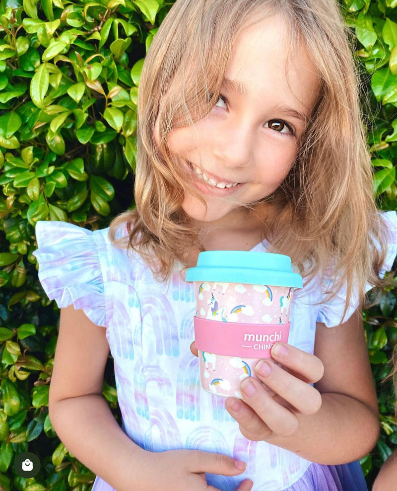 girl holding pink and blue unicorn babycino cup