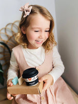 girl holding black and white zoo design babychino cup