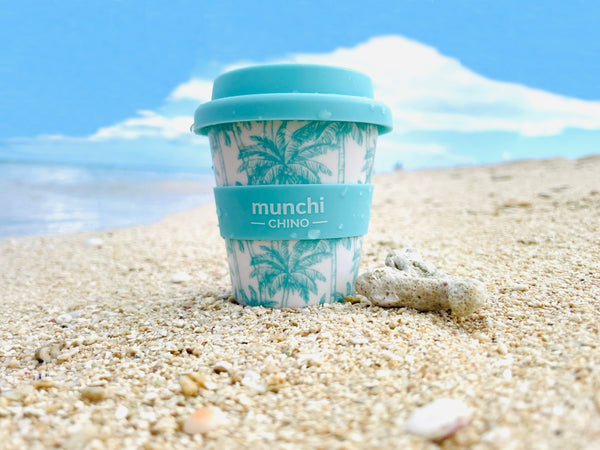 blue and green palm tree design mini babychino cup on tropical beach 